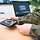Ein Soldat in Uniform verbindet an einem Schreibtisch ein Laptop mit anderer Hardware.